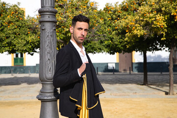 Portrait of young and handsome gipsy man, dressed in black and red shoes dancing with a black and...