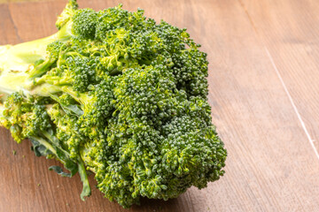 Raw fresh broccoli on old wooden table.
