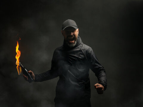 emotional portrait of a man with a molotov cocktail in his hands. a man throws a Molotov cocktail. the concept of protest and resistance