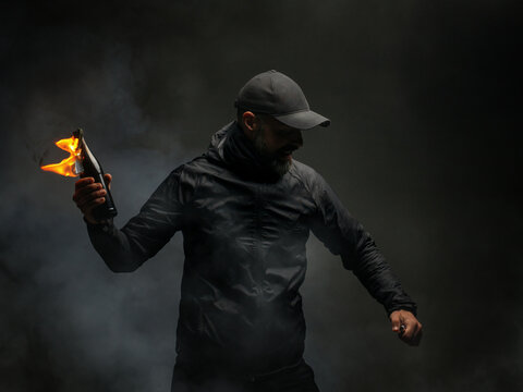emotional portrait of a man with a molotov cocktail in his hands. a man throws a Molotov cocktail. the concept of protest and resistance