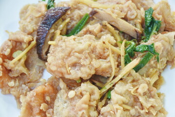 spicy deep fried slice bass fish with ginger and chili on plate