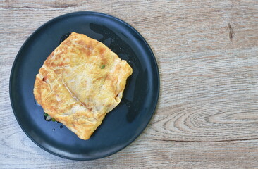 fried mashed pork with tomato and onion stuffed in Thai egg omelets on dish