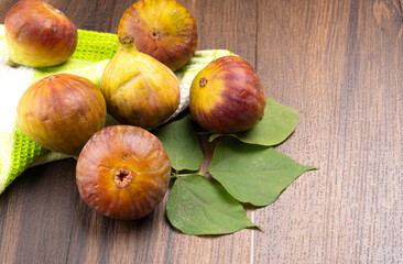 Freshly ripe figs. Healthy Mediterranean fig fruit. Fresh figs on a dark background. Beautiful blue violet figs with leaves, copy space, closeup