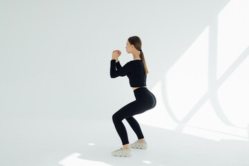 Fototapeta na wymiar Healthy fitness girl with doing workout squat exercise isolated on white background