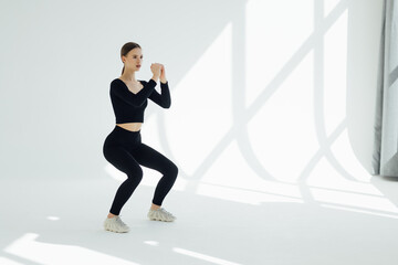 Healthy fitness girl with doing workout squat exercise isolated on white background