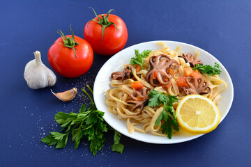 italian pasta with seafood and garlic on dark blue background