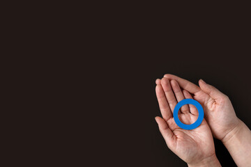 World diabetes day inscription. Blue circle in woman hands on a black background. 14 november.
