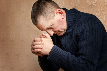 A man with his head bowed during prayer, a Christian prays