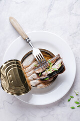 Canned sprats  sandwiches on white plate. Sprat in oil top view.