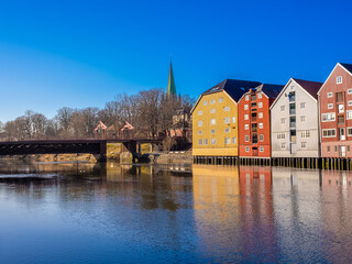 Obraz premium Scenes on the shores of the Nidelva river, with the old town bridge and the spire of the Nidaros Cathedral, Old town of Trondheim, Trøndelag, Norway