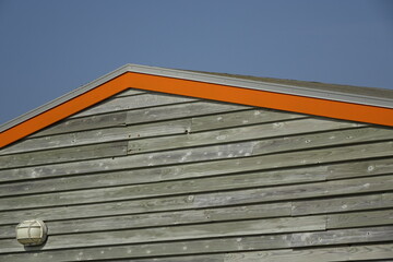Orange gable of wooden beach hut at the North Sea, concept: background, copy space (horizontal),...
