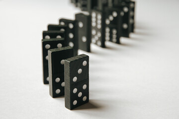 Black dominoes chain on white table background