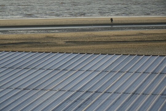 Grey metal roof of beach hut over sandy North Sea beach, use: background, copy space (horizontal), Zandvoort, North Holland, Netherlands