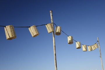 Basket lanterns on power line under a blue sky (horizontal), Zandvoort, North Holland, Netherlands - obrazy, fototapety, plakaty