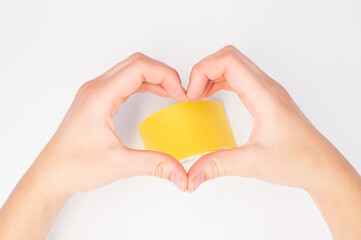 Obraz premium Female hands making sign Heart by fingers. Sticks tape patch for face taping isolated on white