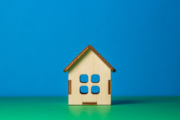Small wooden toy house on a colored background. Real estate purchase and sale concept. real estate services