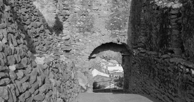Black and white shot of the remains of an old entrance gate of a medieval castle in Cervera del Maestre, Castellon province, Spain