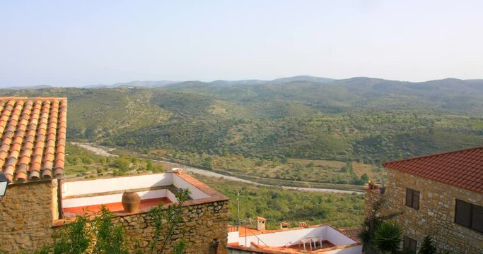 Beautiful panoramic view over residential houses in Castellon province, Cervera del Maestre, Spain. Mountain range covered with lush green vegetation visible in a distance.