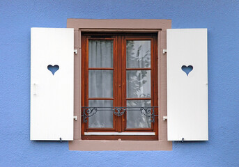 window with closing shutters with heart-shaped carving