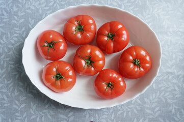 red tomatoes in a white plate on the table