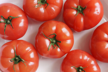 red tomatoes in a white plate on the table