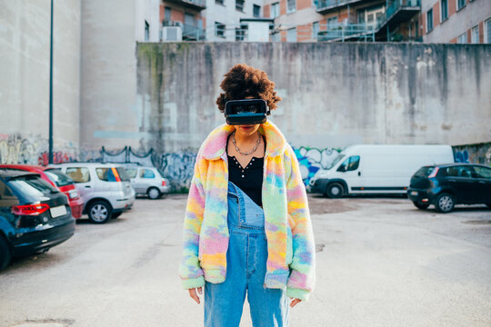 Young black stylish woman outdoor using 3D goggles augmented reality