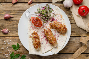 Lula kebab chicken with tomato sauce and red onion top view