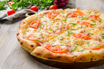 pizza with chicken and vegetables and bacon on grey wooden table macro close up
