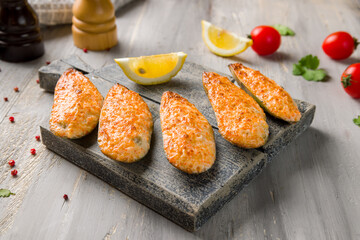 Baked mussels on the board on grey wooden table macro close up