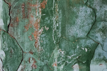 Old shabby cracked green wall background.
