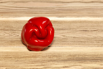 Naklejka na ściany i meble Ugly crooked red pepper on wooden background