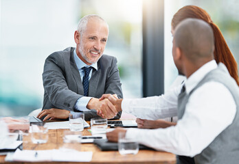 Happy to have you with us. Cropped shot of businesspeople shaking hands during a meeting in an office.