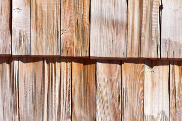 the texture of the wooden shingles covering the wall of the house