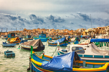 Fototapeta na wymiar Marsaxlokk harbor with multicoloured boats Malta