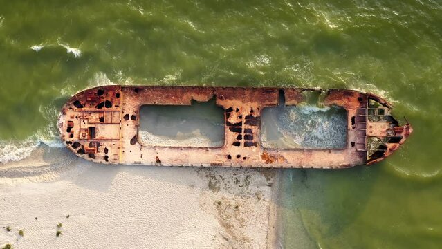Ship resting on her side surrounded by shallow sea water. Aerial view. Kinburn Spit