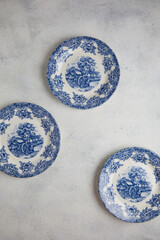 Vintage English porcelain. Very old saucer with blue floral decor, top view, close up.