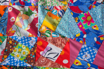 Background of Part of patchwork quilt with flower print. Handmade color blanket in style patchwork. - obrazy, fototapety, plakaty