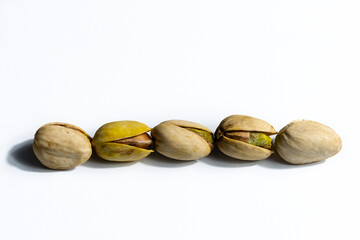 Peeled roasted pistachios isolated on white background