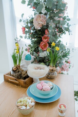 Tree branches with easter painted eggs on gray background with long shadows. Easter holiday home decoration. Home decoration with flowers.