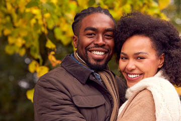 Portrait Of Loving Couple On Walk Through Autumn Countryside Together