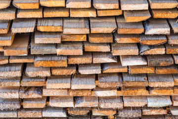 Piles of wooden boards in the sawmill, planking. Warehouse for sawing boards on a sawmill outdoors. Wood timber stack of wooden blanks construction material. Industry.