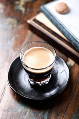 Coffee in glass cup on rustic wooden background. Close up.