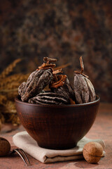 dried persimmon in a clay cup on a dark brown background. Dried fruits