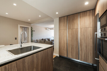 Kitchen with wall to wall oak furniture, stainless steel appliances and exit to a dining room