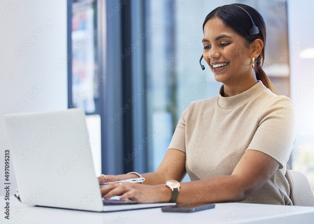 Poster Customers love her friendly manner. Shot of a young businesswoman wearing a headset while working on a laptop an office.