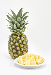 Fototapeta na wymiar Pineapple and bowl of chopped pineapple