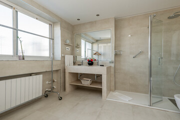 Bathroom with cream marble sink with frameless mirror and access to a bedroom with large window