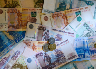 Russian rouble coins against the background of Russian banknotes