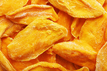 Pieces of sweet dried mango close-up as a background in full screen