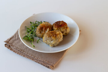 Cutlets with sprigs of thyme on a white plate.